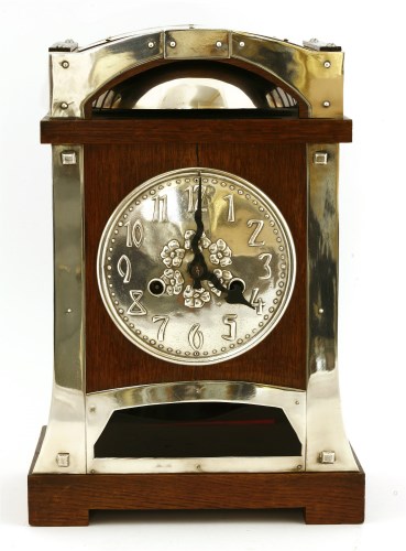Lot 11 - A Continental oak and silver-plated mantel clock