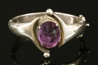 Lot 699 - A sterling silver Taxco Mexican single stone crossover cabochon amethyst hinged bangle
