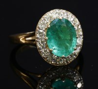 Lot 356 - An 18ct rose gold emerald and diamond oval cluster ring