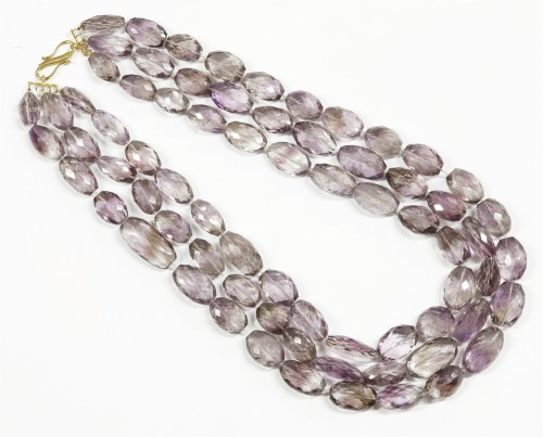 Lot 35 - A three row graduated oval faceted amethyst bead necklace