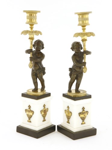 Lot 1114 - A pair of Regency bronze and parcel gilt candlesticks