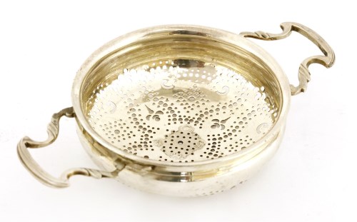 Lot 154 - A George II silver two-handled lemon strainer
