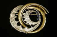 Lot 702 - A yellow and white gold sapphire scrolling brooch