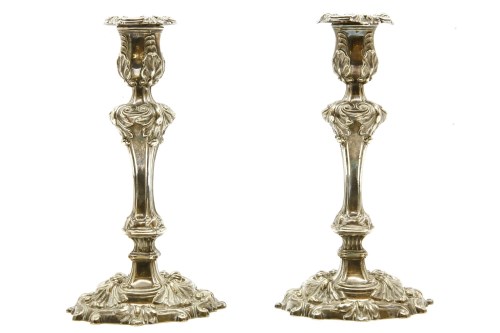 Lot 100 - A pair of Continental white metal and filled candlesticks