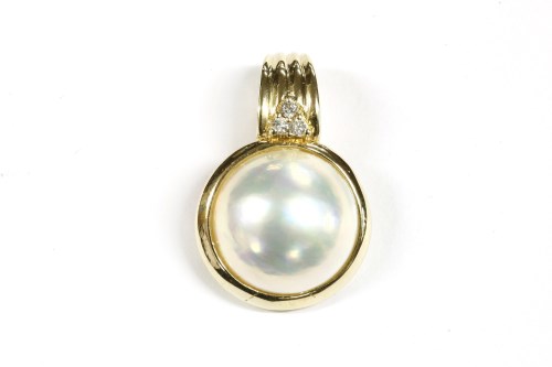 Lot 14 - A gold coloured mabé pearl and diamond set three stone cluster ring