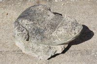 Lot 598 - A weathered cast stone sculpture of a frog resting on a rock