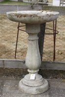 Lot 614 - A three part cast stone classic shaped bird bath with fluted baluster column on a circular base