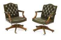 Lot 779 - Two modern green buttoned leather swivel office chairs