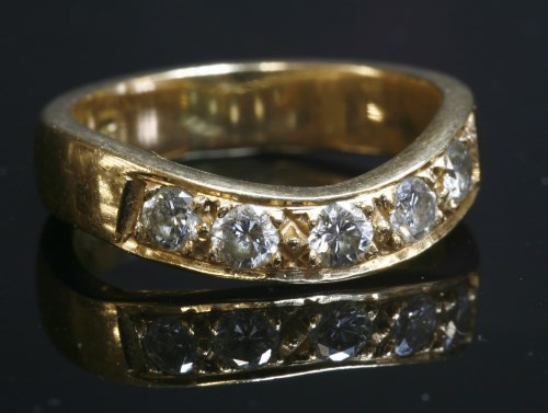 Lot 7 - A gold diamond set wave half eternity ring