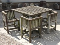 Lot 681 - A teak garden table and four chairs of slatted design