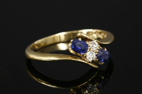 Lot 6 - An Edwardian 18ct gold four stone diamond and sapphire crossover ring