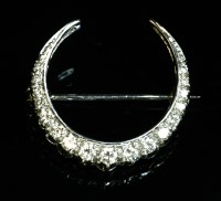 Lot 166 - An 18ct white gold diamond set crescent brooch