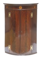 Lot 247 - A George III strung and inlaid mahogany bow-fronted hanging corner cupboard