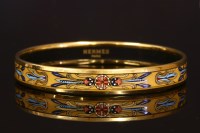 Lot 514 - An Hermès narrow enamel printed bangle with gold-plated guards