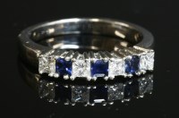 Lot 300 - A seven stone sapphire and diamond half hoop ring