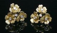 Lot 196 - A pair of 18ct gold diamond set flower cluster earrings