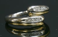 Lot 302 - A two colour gold diamond set crossover ring