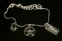 Lot 534 - A Christian Dior silver-plated charm bracelet.
three Dior charms