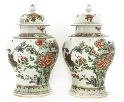 Lot 115 - A pair of Chinese famille rose vases and covers