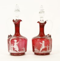 Lot 167 - A pair of Mary Gregory overland cranberry glass claret jugs and stoppers