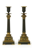 Lot 174 - A pair of French Empire style bronze and ormolu candlesticks