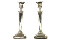Lot 137 - A pair of filled silver candlesticks of tapering angular form