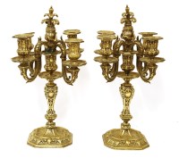 Lot 803 - A pair of polished bronze four-light candelabra