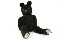 Lot 218 - A black plush teddy bear with green glass eyes