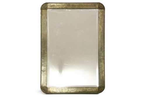 Lot 573 - An Art Deco design brass hammered bevelled mirror
