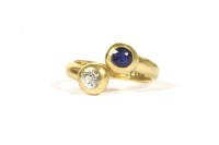 Lot 216 - A gold two stone diamond and sapphire crossover ring