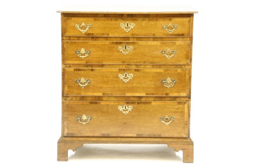 Lot 506 - A George III oak and mahogany cross banded chest of four graduated drawers