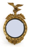 Lot 405 - A Regency style gilt circular convex mirror with eagle surmount