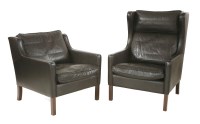 Lot 463 - Two Danish high and low back black leather lounge chairs