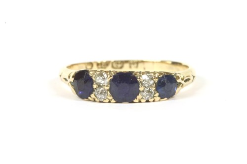 Lot 70 - An 18ct gold three stone sapphire and stone ring
