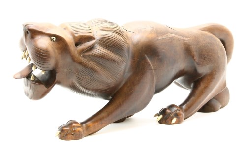 Lot 167 - A Japanese carved hardwood figure of a prowling lion