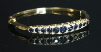 Lot 297 - An 18ct gold sapphire and diamond hinged bangle