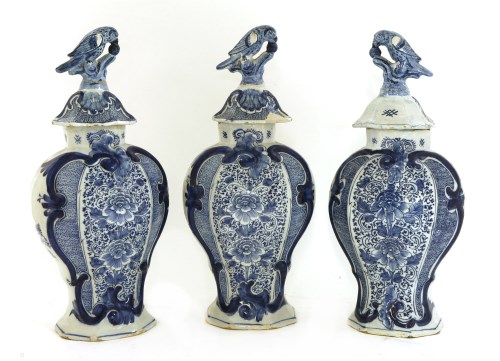 Lot 507 - A garniture of three blue and white Dutch delft vases and covers