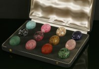 Lot 680 - A cased set of twelve carved specimen hardstone eggs