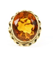 Lot 66 - A gold single stone oval cut mixed citrine ring