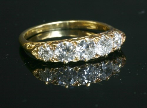 Lot 59 - An Edwardian five stone diamond carved head ring