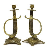 Lot 937 - A rare pair of sword hilt candle holders