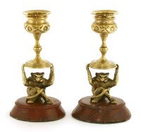 Lot 943 - An attractive pair of monkey form candlesticks