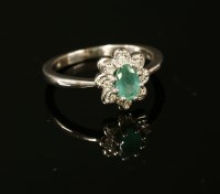 Lot 30 - A 9ct white gold emerald and illusion set diamond daisy cluster ring