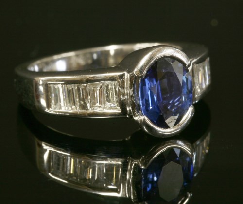 Lot 294 - A Continental white gold sapphire and diamond ring with an oval mixed cut sapphire