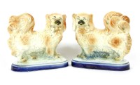 Lot 309A - A mirrored pair of late 19th to early 20th century Staffordshire figures depicting standing Pekingese dogs