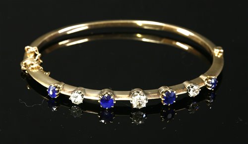 Lot 58 - An Edwardian sapphire and diamond hollow hinged bangle