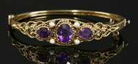 Lot 665 - A Victorian style amethyst and split pearl hinged bangle