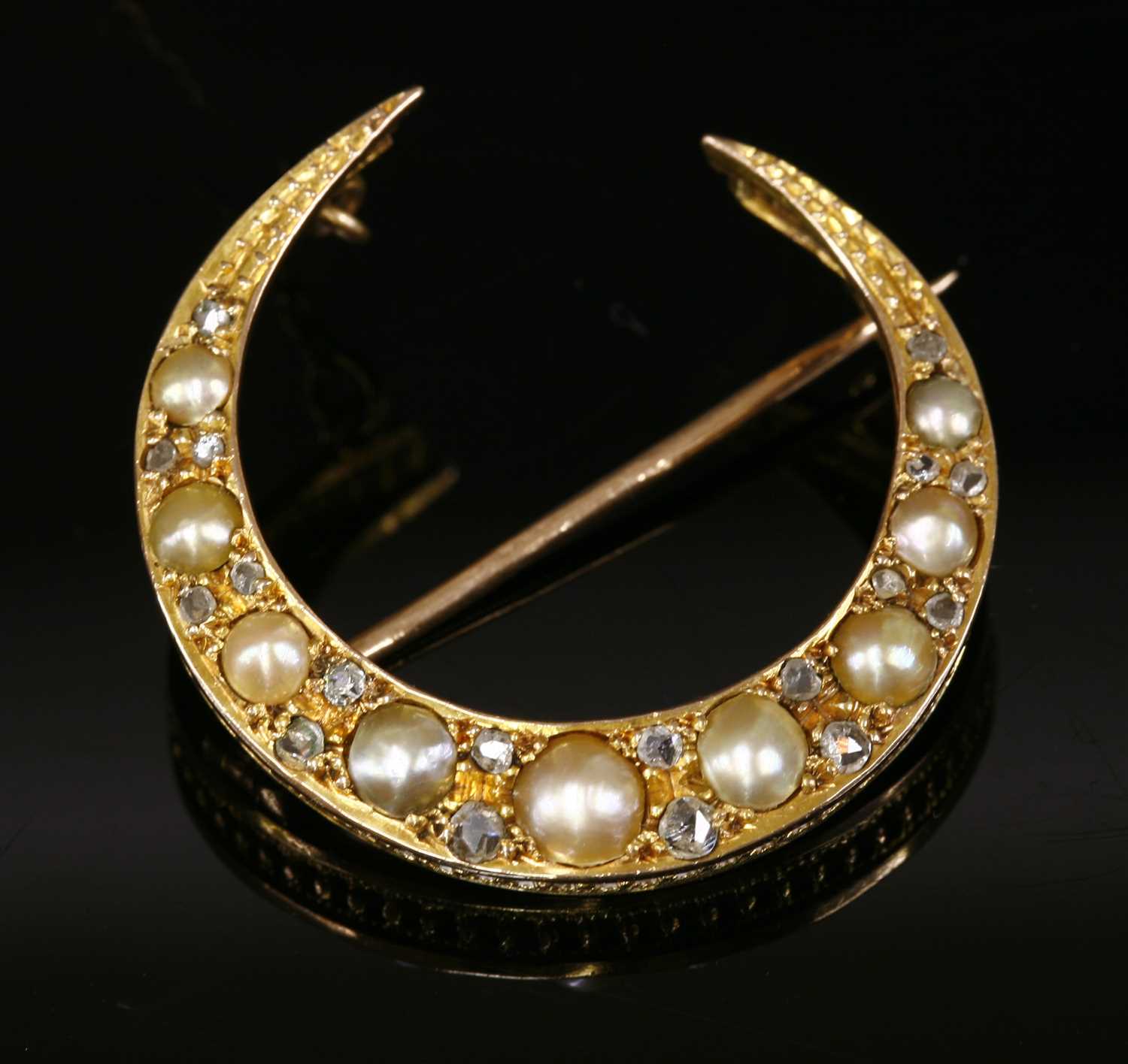 Lot 87 - An Edwardian gold split pearl and diamond crescent brooch