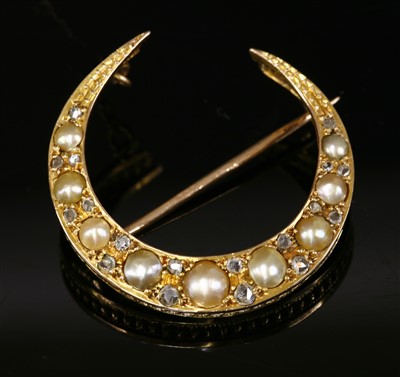Lot 87 - An Edwardian gold split pearl and diamond crescent brooch