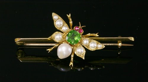 Lot 97 - An Edwardian gold, green paste, ruby and split pearl set insect bar brooch, c.1905